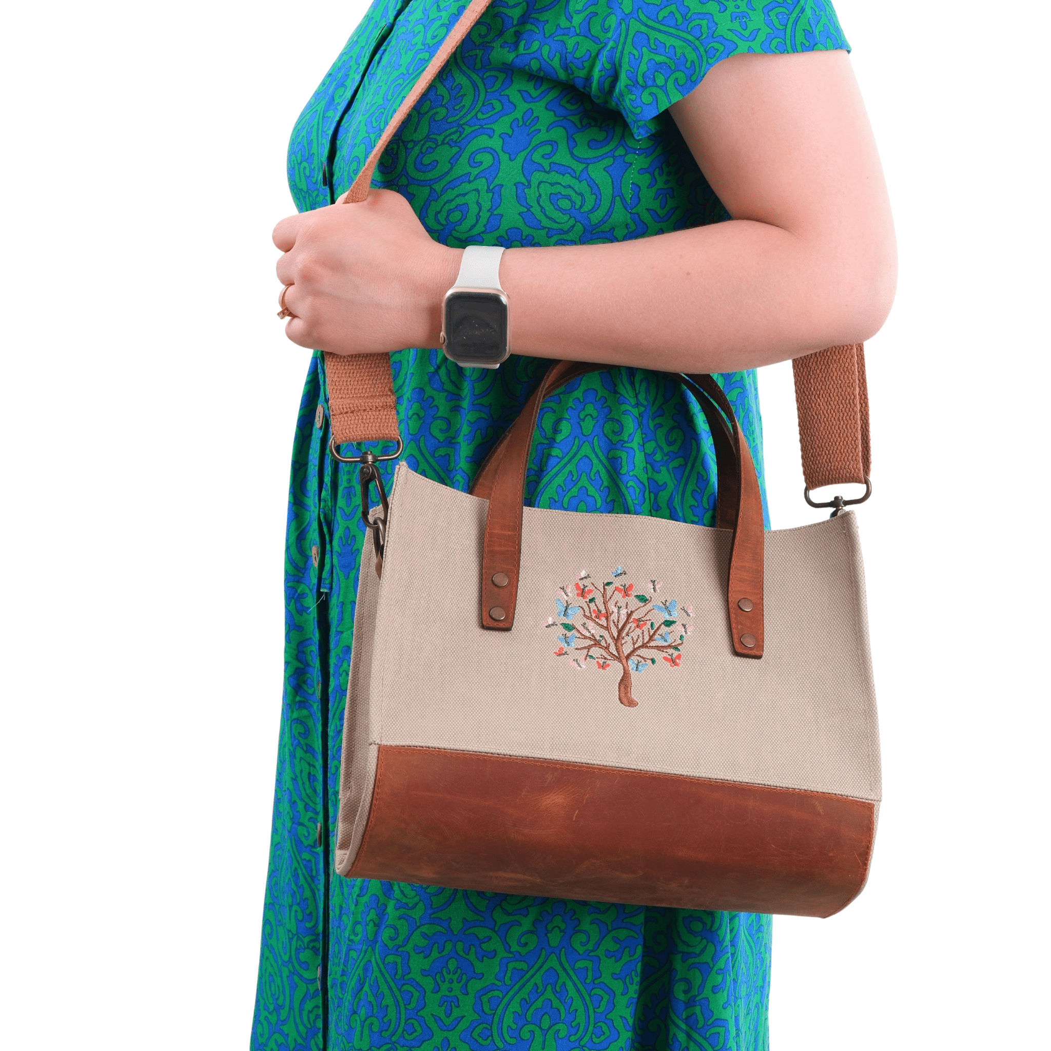 Woman holding Butterfly Tree shoulder bag – cream canvas & brown leather